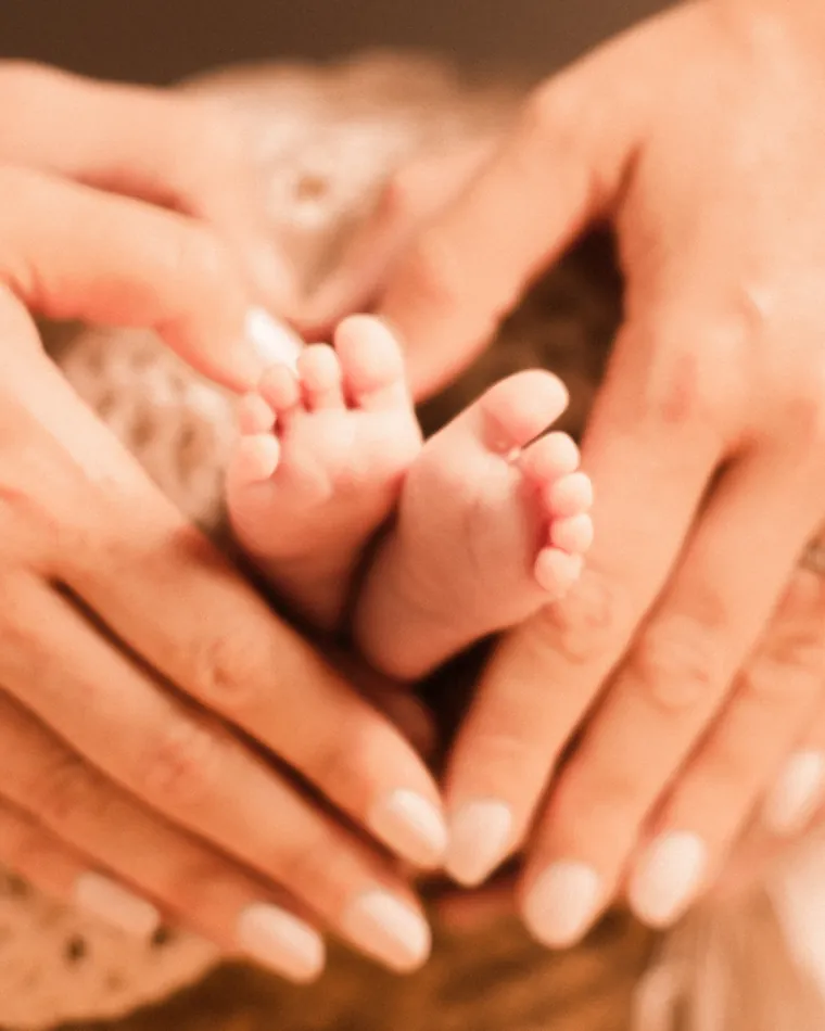 Chéile Wellbeing perinatal mental health support: a mother's hands cradling her newborn baby's feet