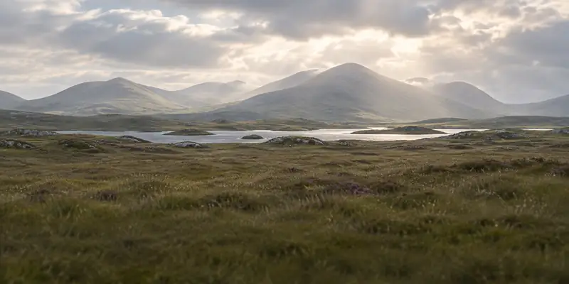 Mountains, lakes and bogland under a soft sky in the West of Ireland
